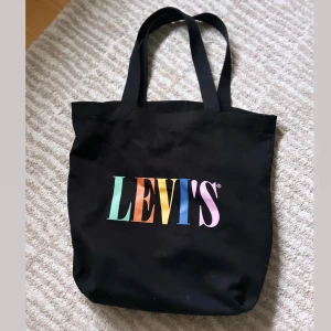 Levis påsväska  - En svart påsväska med färgglatt tryck ”Levis” 