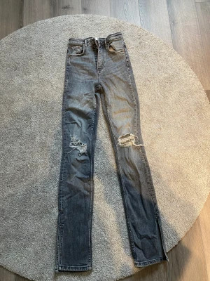 Gråa jeans med slits  - Gråa jeans med slits från Zara Storlek 32 Använda endast 1 gång