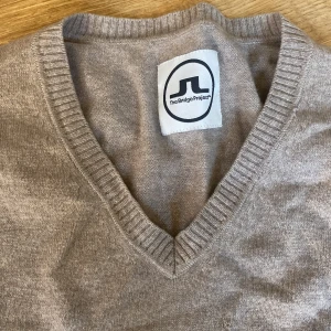 100% cashmere beige soft tröja - Beige v krage tröja från j lindeberg i 100% cashmere. Jättefin och mjuk. Färgen syns bättre på första bilden. 