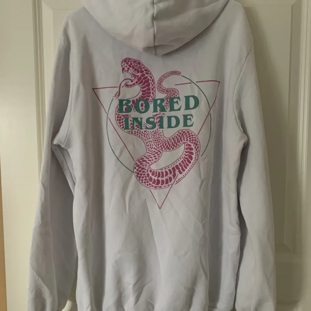 Hoddie med litet tryck fram och ett större på ryggen. Hoodies.