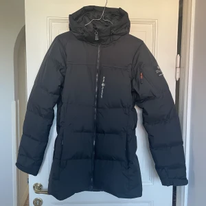 Sail Racing jacka strl.M - Svart dunjacka från Sail Racing i storlek M. I mycket fint skick. Kemtvättad helt nyligen och inte använd efter det.