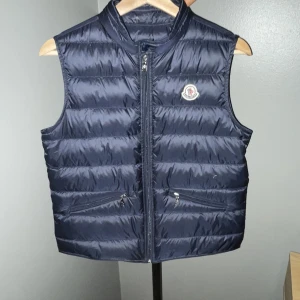 Moncler Gui Down Väst (Kvitto finns) - Jag säljer nu min moncler gui down vest då den börjar bli lite för liten för mig. Västen är i bra skick förutom lite märken på ryggen. Jag köpte västen från farfetch för 4180 kr men nu kostar den ny ca 7100 kr  Hör av er för mer info och bilder  Mvh/Linus