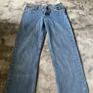 Ett par mörkblåa low waist straight jeans. Jeansen har slits längst ner på benen. På den sista sidan ser man att jag har klippt dom. Kontakta för mer information 