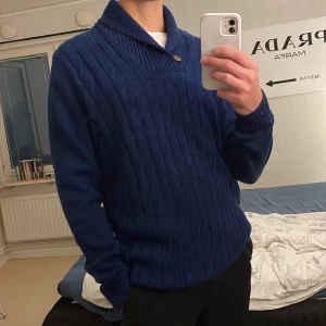 Marinblå Kabelstickad tröja - En blå kabelstickad tröja med sjalkrage från Hampton republic. Tröjan är i utmärkt skick och har inga hål eller andra defekter. Den är i storlek large. Perfekt till hösten och vintern. Hör av dig för fler bilder eller frågor.