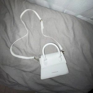 Vit handväska - Chic handväska, kan användas med band eller med bara handtaget. Ganska liten men rymmer alla nödvändigheter! I ny skick!