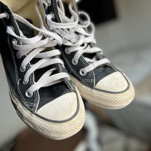 Svarta converse - Ett par svarta converse i storlek 35. Väl använda och lite slitna framtill (bild 2). Längst sidorna finns smuts som jag inte lyckats fått bort💞 Jag säljer för 230kr + frakt (nypris ca 550kr-800kr) Katt i hemmet!💞💞