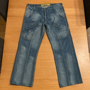 Vintage Vita Bella Jeans - Ett snyggt par jeans med tydliga sömmar och extra fickor vid låren. En snygg wash kombinerat med detaljer som extra ”hemming” och slutligen unika bakfickor gör dessa schyssta. Ingen sizing, men stora Längd 94cm Midja 43x2 Skriv om det finns frågor :)  