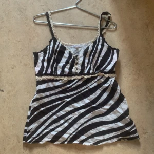 Zebra randig topp - En super gullig topp från sara kelly i storlek 42 vilket jag tror är ty medium eller large men den passar bättre på storlek M eller S ränderna är bruna och vita 