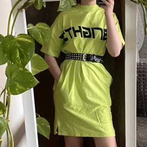 Grön sweaterklänning  - Grön klänning i tjockt skönt material med fickor. Svart tryck ”Bright” över bröstet. Helt oanvänd. Grönare i verkligheten än på bild. (SKÄRP INGÅR EJ!!) 🦖