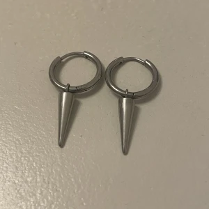 Edblad Peak Hoops Steel - Säljer dessa så coola örhängen från Edblad, den stora modellen. Fint skick. Det ena örhänget har blivit lite böjt just där det träs igenom örat som syns på bild 2, detta syns dock inte alls när örhängena är på. 