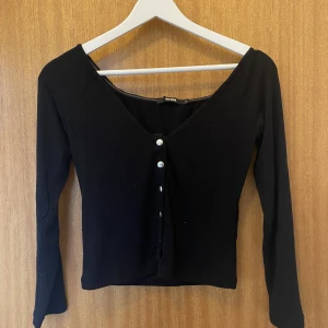 Fin topp från bikbok  - Svart topp från BikBok i storlek S, inte mycket använd men lite nopprig på vissa ställen. Sitter fint på. Går att knäppa upp vid knapparna.