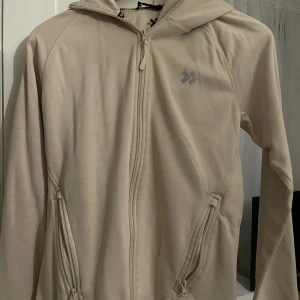 Beige tränings huvudtröja - Säljer denna beige tränings huvudtröjan då den är för liten. Den har aldrig användas och därför i nyskick. Det står storlek L på lappen men den passar dig som har storlek S. Hör av er vid intresse eller ev frågor!😀