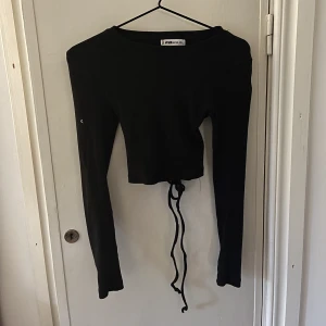 Fest topp - Svart fin långärmad från med knytning bak i ryggen! 