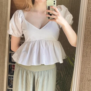 Vit blus - Vit prinsessliknande blus 👑💝 Babydoll waistline och puffiga armar. Har haft ett hål vid dragkedjan vilket jag sytt ihop (bild 3). Tyget är sturdy men inte stretchigt därav dragkedjan 👍 Perfekt för både fest och vardagsanvändning 🤍
