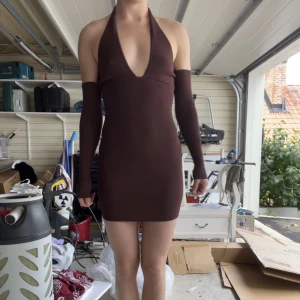 Klänning - Så unik och snygg klänning från en tidigare kollektion av Bershka. Ärmarna ser ut att sitta löst, men har ett fäste vid armhålan. Överdelen är i halterneck-modell och mid i längden. 