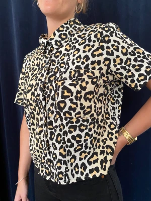 Skjorta i Leopardmönster - Fin t-shirt skjorta i leopardmönster. Skönt tyg och bra skick!