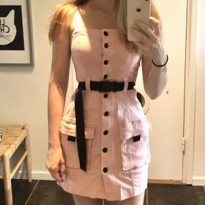 Kort rosa klänning - Söt kort klänning med knappar i storlek xs. Justerbar arm längd, fråga för fler bilder <3. Aldrig använd då det inte är min stil. 