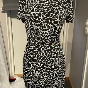 Spräcklig klänning  - Använd en gång på bröllops efterfest. Märke på framsidan. 