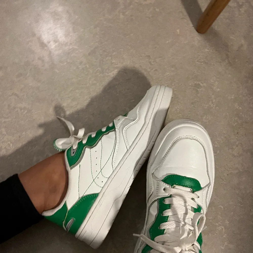 Vita sportiga sneakers i retro-stil med gröna detaljer och grov sula. Köpta på Zara, i storlek 41. Använda 3ggr bara så de säljs i fint skick! 🤍💚. Skor.