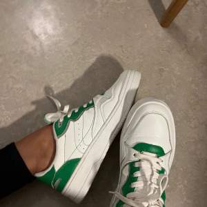Vita sportiga sneakers i retro-stil med gröna detaljer och grov sula. Köpta på Zara, i storlek 41. Använda 3ggr bara så de säljs i fint skick! 🤍💚