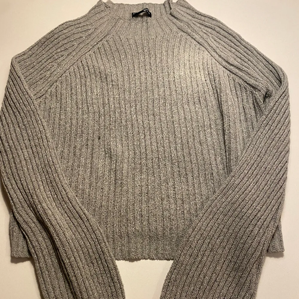 En grå stickad tröja med ganska långa ärmar. Den är helt oanvänd då den inte riktigt är min stil.. Stickat.