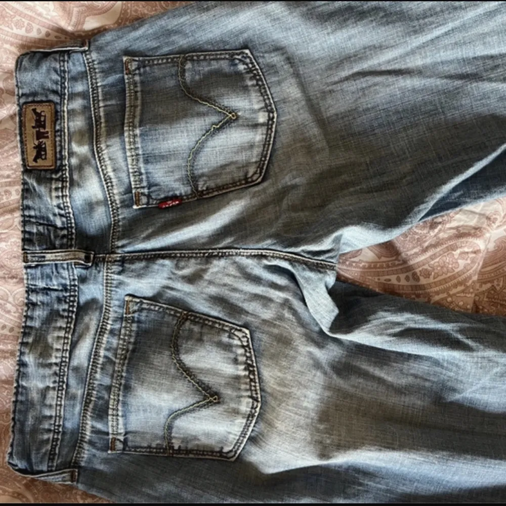 Ljusblå lågmidjade jeans från Levi’s. Midjemått: 36cm Innerbenslängd: 77cm.. Jeans & Byxor.