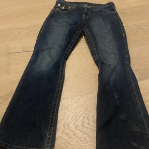  bootcut true religion jeans  -  True religion jeans jättefina jeans med coola fickor med knappar, utsvängda i benen låg midjade 