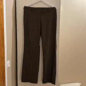 Lågmidjade kostymbyxor - Skitsnygga lågmidjade utsvängda kostymbyxor. Innebenslängden är 76cm och midjemåttet 41 tvärs över. 