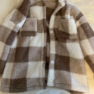 Rutig jacka - Jag säljer en super mysig oversized brun,vit rutig jacka! Den är nästan aldrig använd, super bra skick. Ger jätte mycket ”Stockholmsstil” vibe vilket är väldigt trendigt just nu! Det är storlek S men eftersom den är oversized passar den M oc
