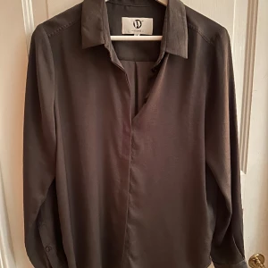 Wakakuu icons blus - Silke. Storlek S. Knappt använd. Wakakuu icons. Mörkgrå/lila färg