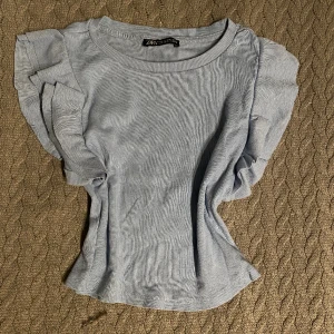 Ljusblå topp - En söt ljusblå topp från zara i storlek medium. Den är i bra skick.