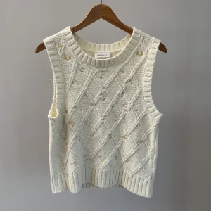 Stickad väst Monki.  - Stickad väst med blommor på från Monki. Sparsamt använd så i mycket fint skick.