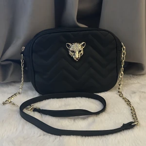 Svart väska - Säljer denna unika svarta väska med ett gulligt leopard huvud som detalj. Kedjan är också guldfärgad 🐆🫶🏼