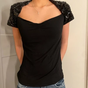 Glitter Topp - Svart super cool och classy topp med en inbyggd svart glitter bolero. Storlek S-M. Mycket bra skick. Köpare står för frakt!