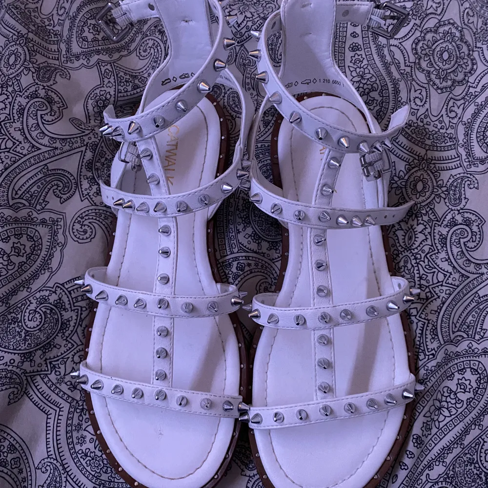 Super snygga vita sandaler med silvriga nitar. Köpa i sommras och använd ungefär 3 gånger. Ända defekter på bild 2. Skor.