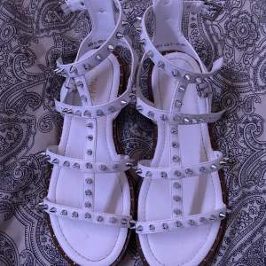 Super snygga vita sandaler med silvriga nitar. Köpa i sommras och använd ungefär 3 gånger. Ända defekter på bild 2