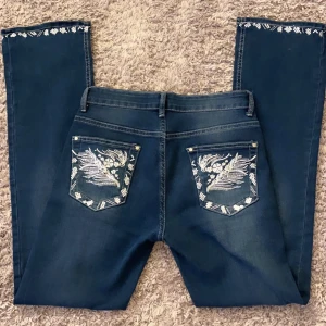 Snygga Jeans - Low waist bootcut jeans med coola broderier! Midjemåttet: 36cm (tvärs över) Innerbenslängd: 79cm. Byxorna är stretchiga så passar även större storlek. Använda fåtal gånger. Använd gärna köp nu! Bara o skriva vid fler bilder eller frågor💘