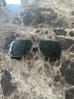 Ray-Ban Solglasögon - Helt oanvända solglasögon i nyskick från det välkända och kvalitativa italienska varumärket Ray-Ban. Priset går att sänkas marginellt. Ordinariepriset ligger på 1820kr.
