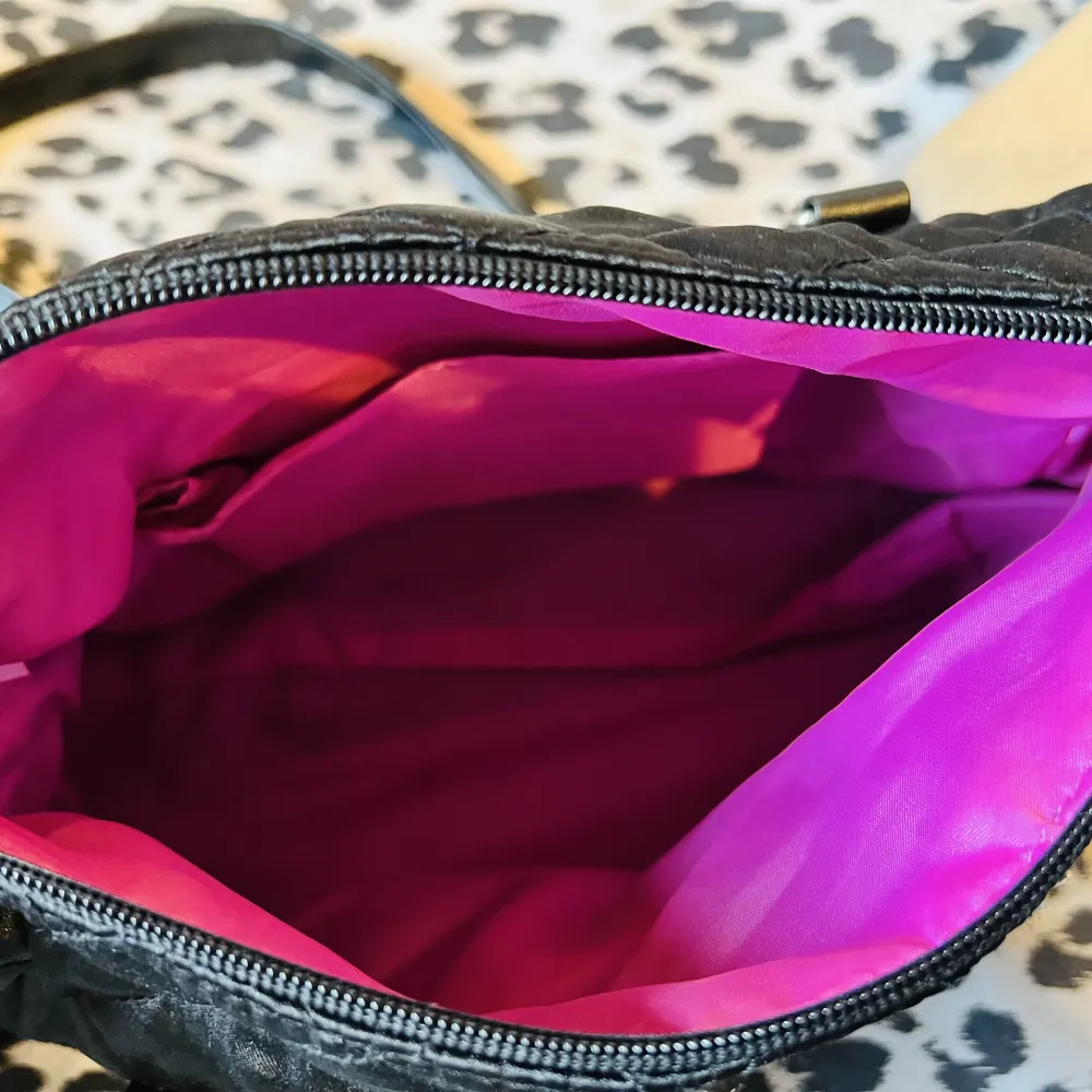 Söt Paris Hilton axel väska.  Mini purse finns i väskan.  Yttre (sido) och inre fack finns.  Färg/ svart, lila.    Ej använd. Väskor.