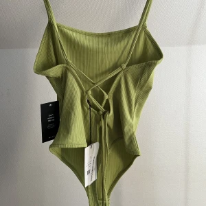 Body - Grön body från NAKD, helt oanvänd med prislappar kvar. 