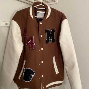 Collegejacka  - Helt ny collegejacka som jag köpte för två månader sedan men aldrig använt. Skicket är 10/10. Jag är M i storleken och den sitter snyggt på mig, lite ”Oversized-fit”