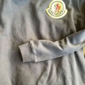En tunn grå sweatshirt från moncler. Använd endast en gång. Har legat i en flyttlåda därför det är lite damm och liknande på tröjan. 