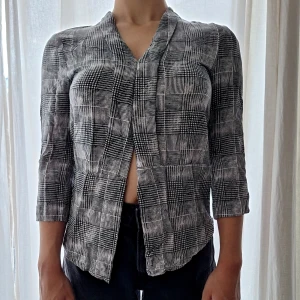 Blus - Asymetrisk blus med svartvitt mönster i tunnt material
