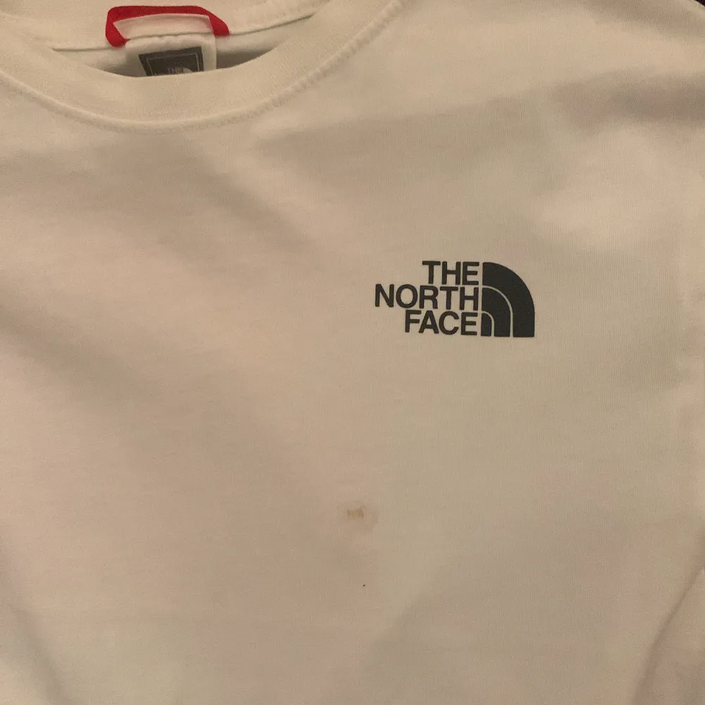 Snygg, vit The North Face t-shirt! Bra skick dock en liten fläck (se bild 2) kan säkert gå bort i tvätten men inte testat. Ordinariepris 399 kronor.. T-shirts.