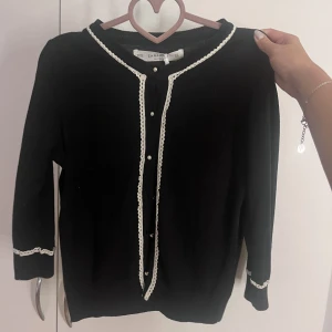 Zara trekvartsärmad kofta - Söt trekvartsärmad kofta från zara med pärlknappar och vita detaljer.