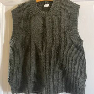 Stickad väst - Stickad väst som är mörkgrön 