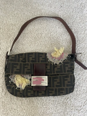 Fendi baguette - Köpte denna väska på The Vintage Bar 2020. Den var sliten redan när jag köpte den. Väskan har fått ännu mer kärlek med åren. Då köpte jag den för 9000kr men säljer för 2800kr då den är sliten men har möjlighet att få tillbaka sitt värde med restaurering. 