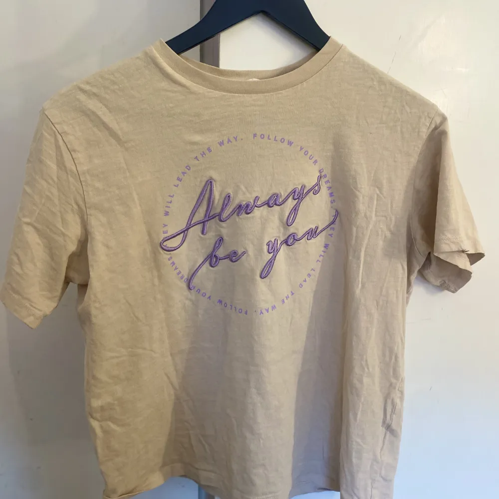 Säljer en bekväm beige tröja med lila tryck💘 Bra skick och perfekt storlek i ärmarna💘 Tål 40 graders tvätt. T-shirts.