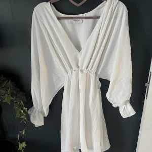 Vit klänning Chiquelle - Underbar vit klänning med resår i midjan och vida armar. Storlek small. Aldrig använd. 