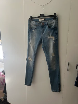 Kristen jeans  - Slim modell, med zip dragkedja på ben. Aldrig använda. Längd 32 på ben.